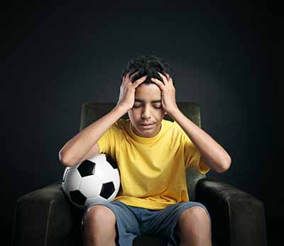 boy with soccer ball who is upset