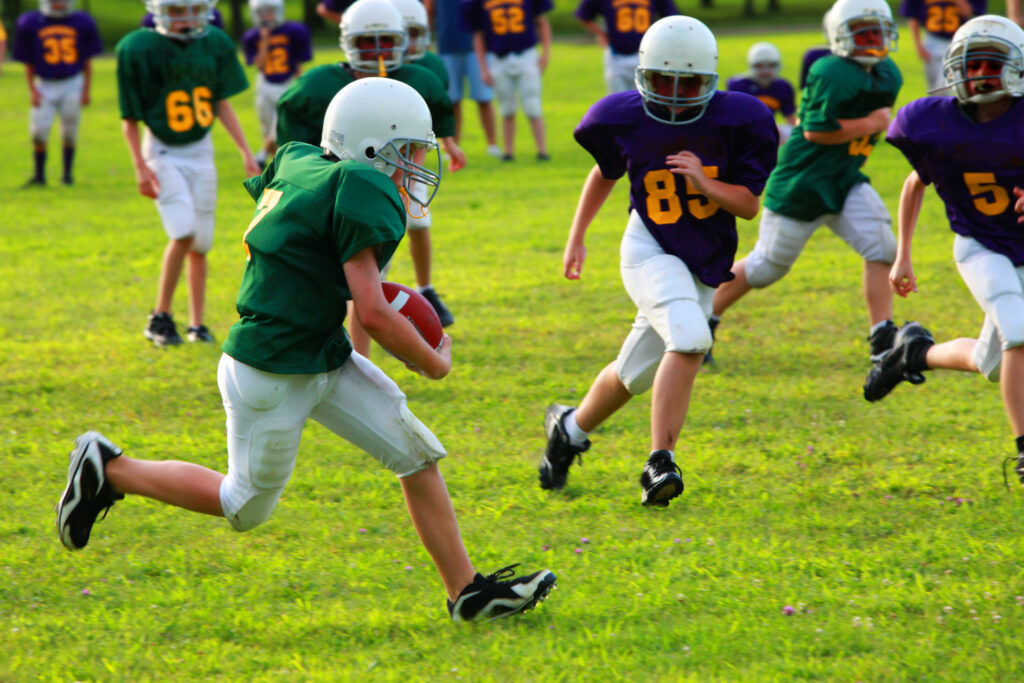 a teen playing football about to be aggressively tackled 