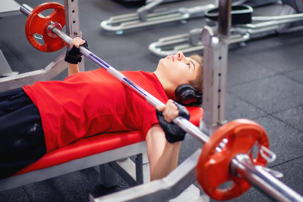 a teen who wants to improve his health lifts weights at the gym