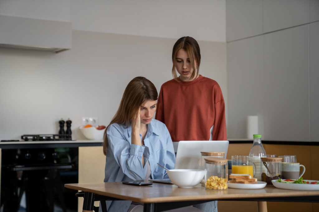 Uninvolved mom is too distracted by working on her laptop to talk to upset daughter.