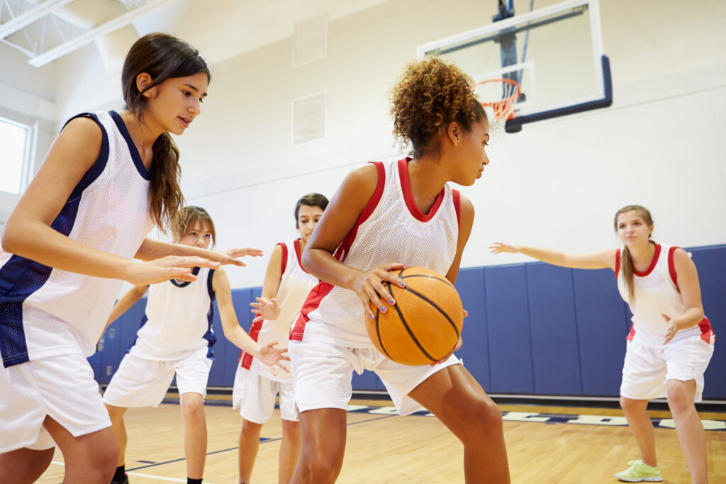 A teenage girl playing basketball after successful treatment, showing how teens and psychiatric medications can help adolescents return to sports and healthy developmental milestones.