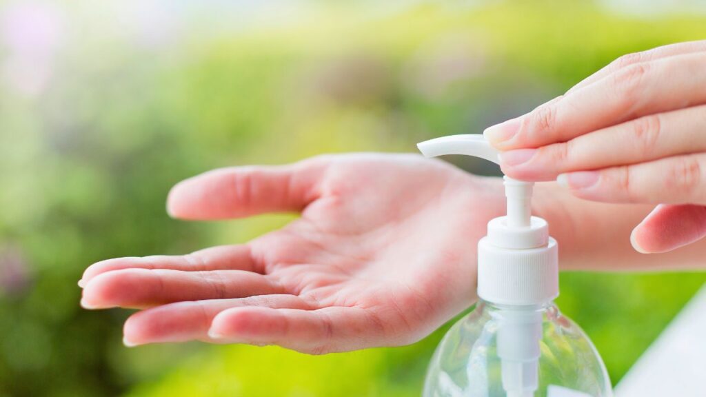 A teen applying hand sanitizer