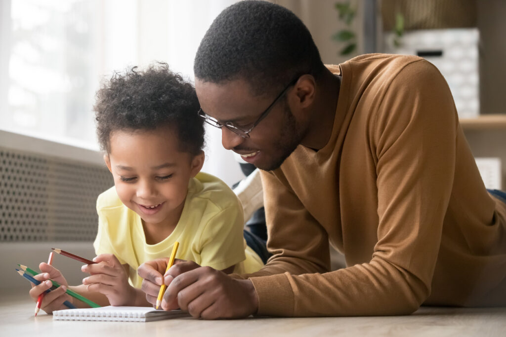 a dad and his young child are bonding over drawing