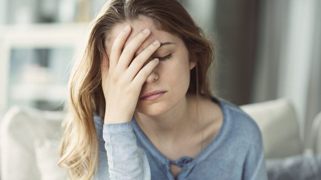 an upset teen does a face palm and feels ashamed remembering what she did while drunk 