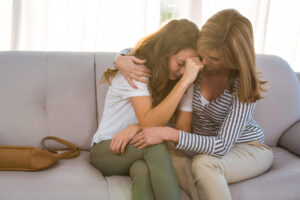 mom comforts teen girl