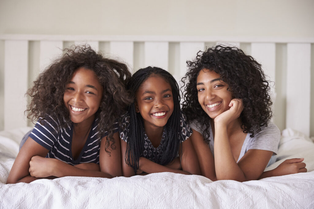 a group of three sisters smiling together