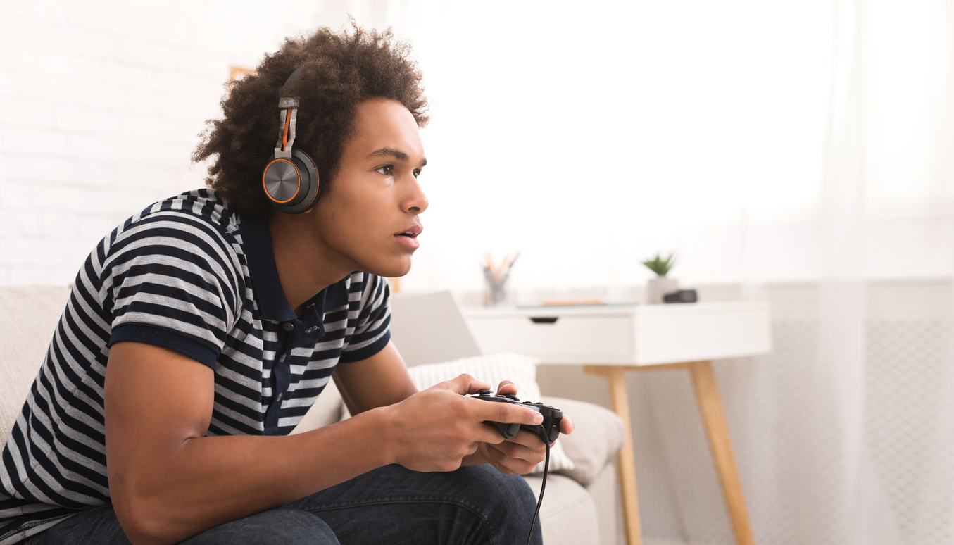 Teenager Boy Online Plays A Computer Game With Headphones And A